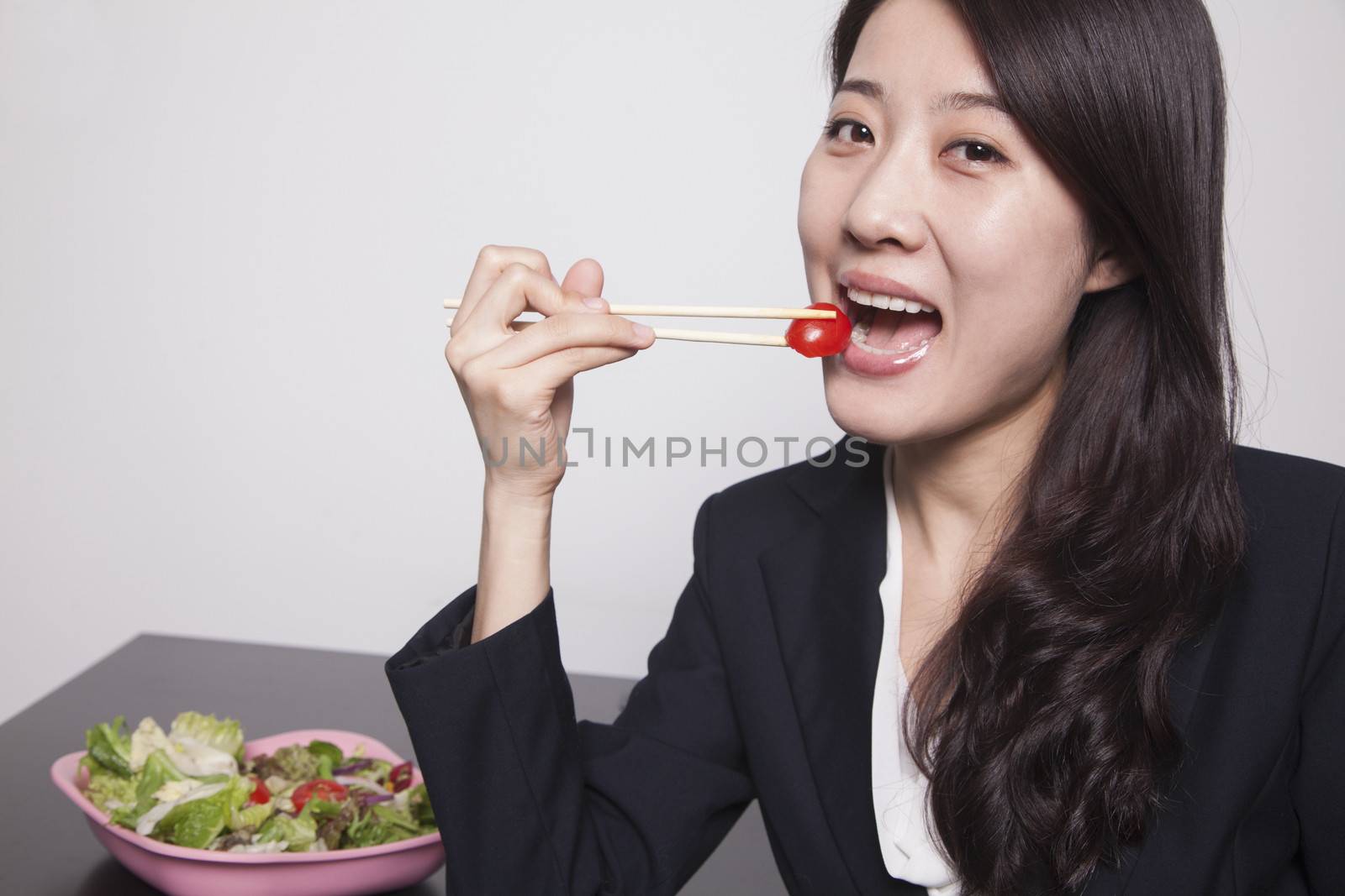 Young businesswoman enjoying a salad, portrait