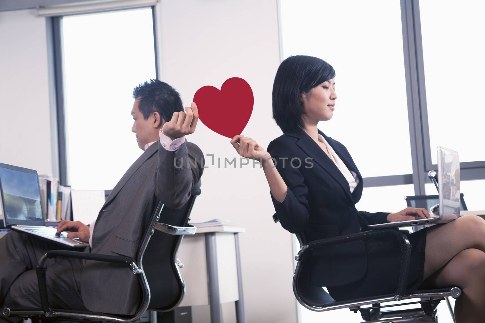 Work romance between two business people holding a heart