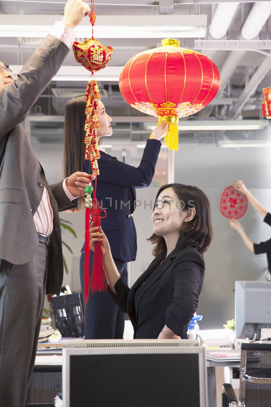 Coworkers hanging decorations in office for Chinese new year by XiXinXing
