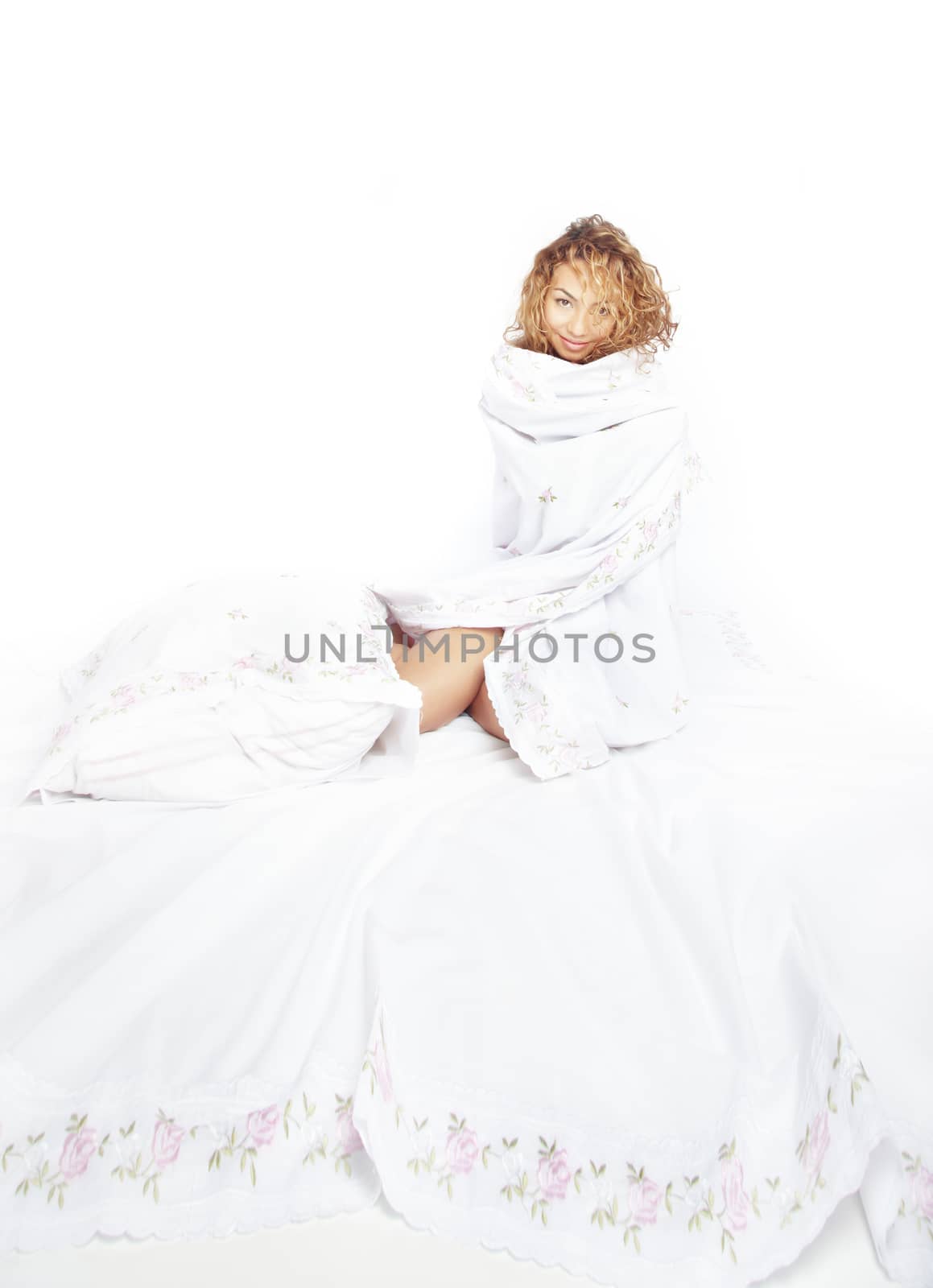 Lady sitting on the bed covered by linen
