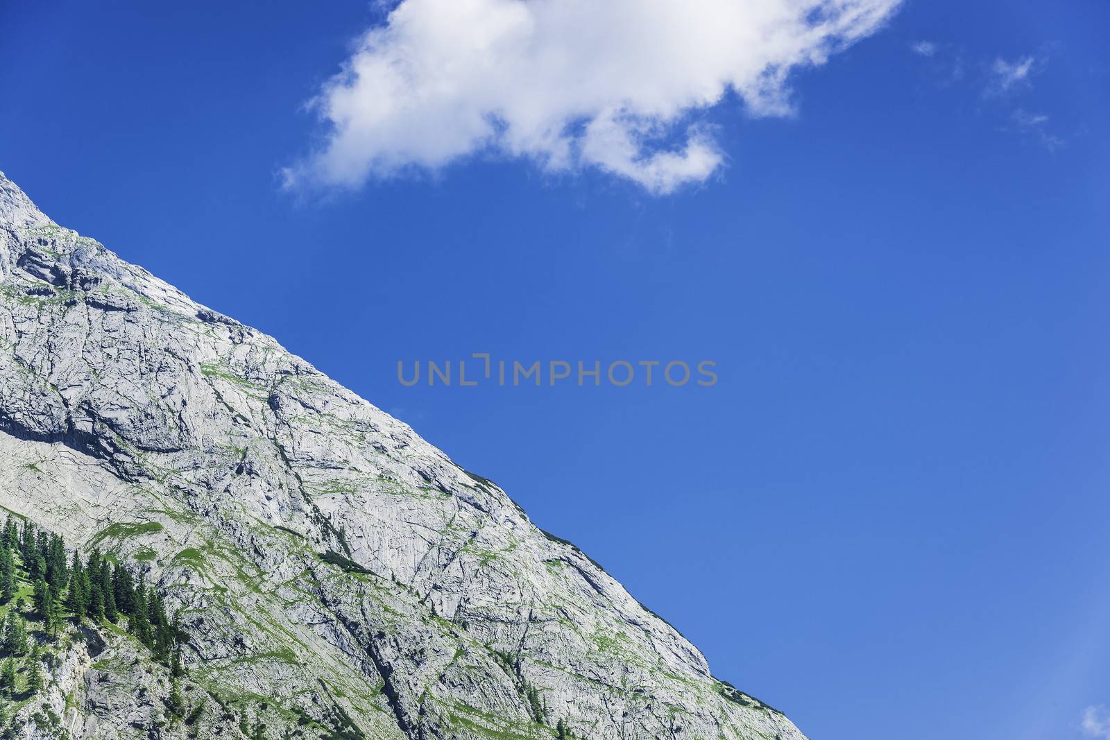 Detail photo of a rocky mountain with blue sky and cloud in the area called Hinterriss in Austria