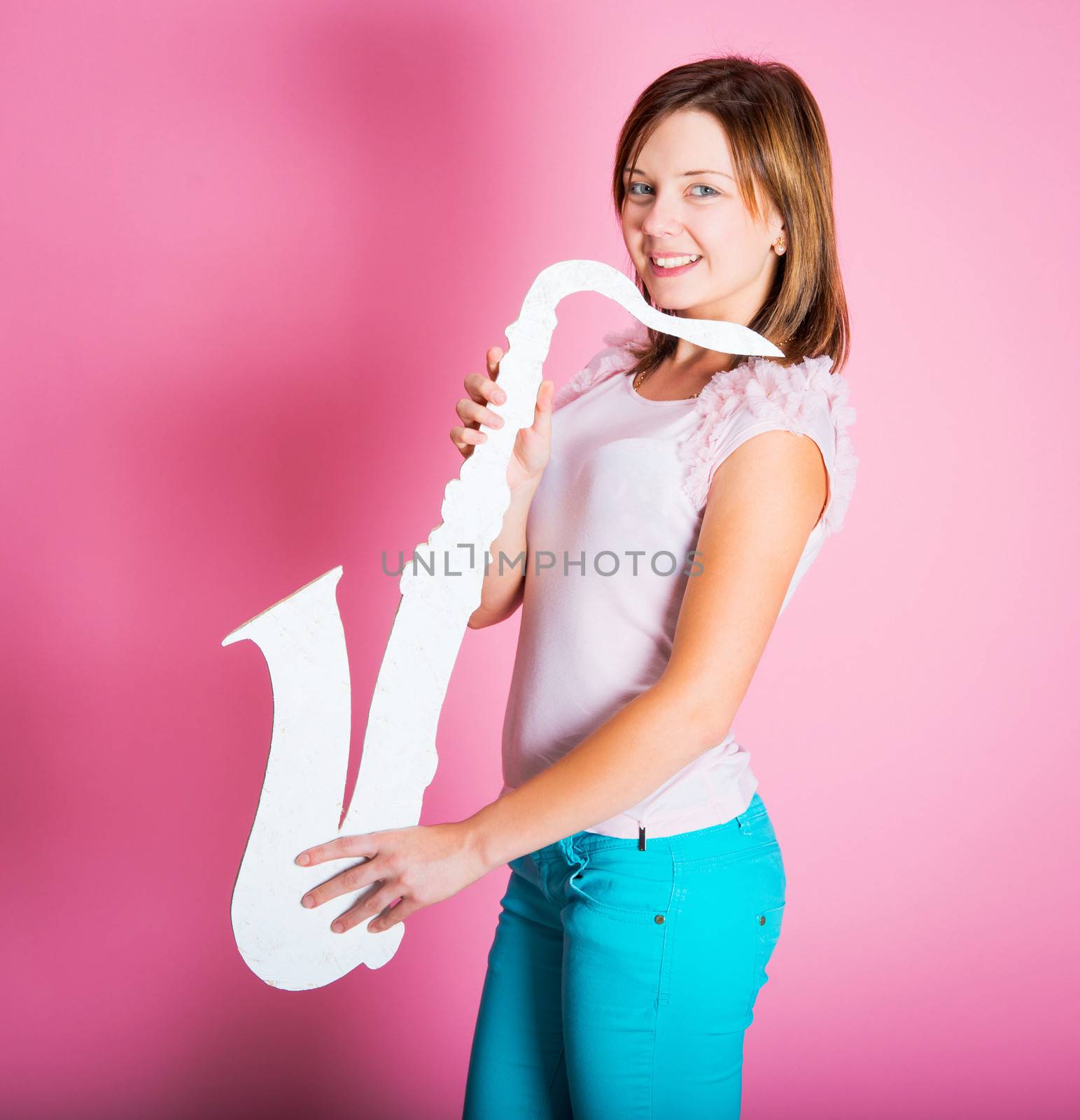 girl with white saxophone on a pink background