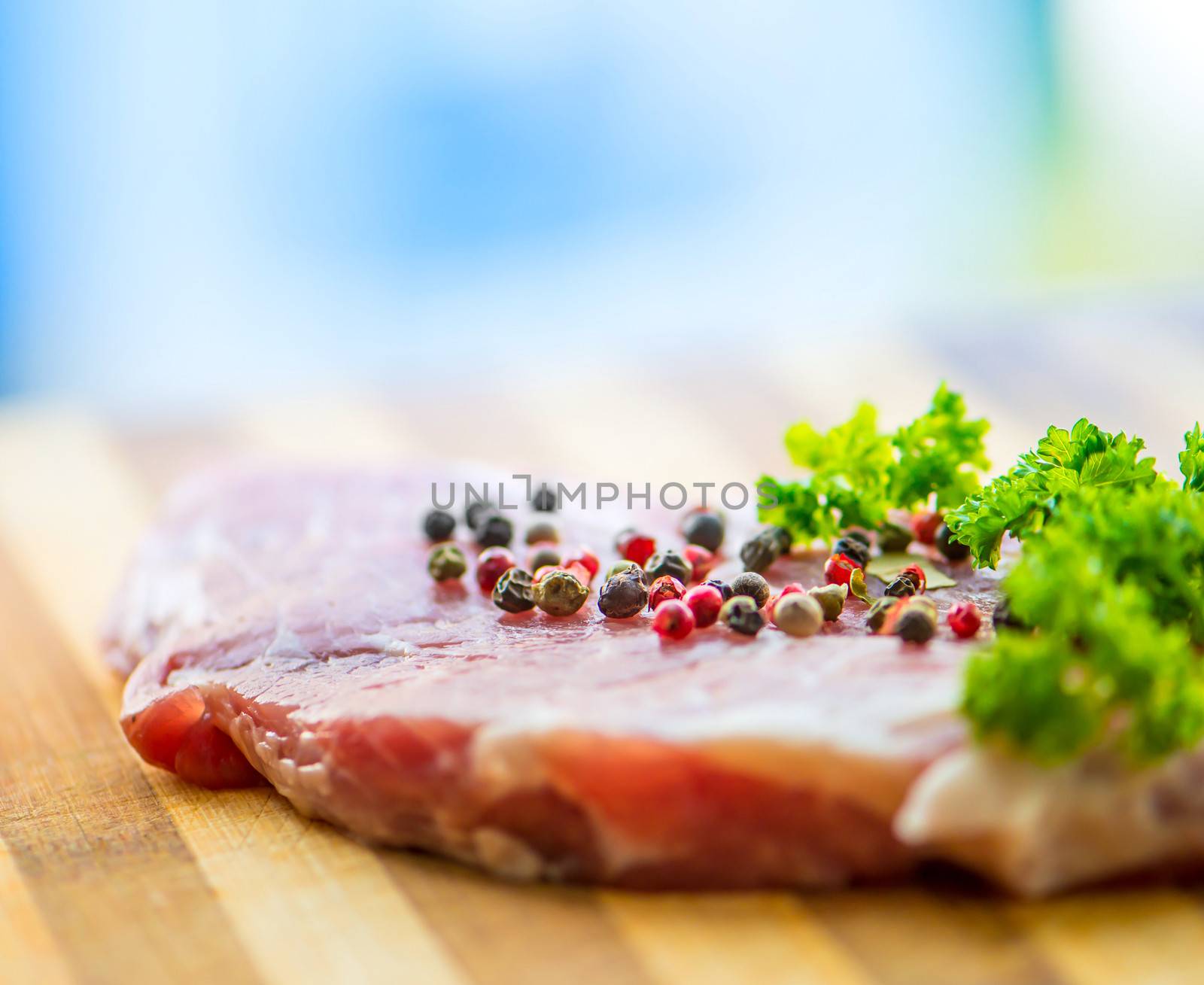 raw meat for steak with pepper and herbs on a cutting board