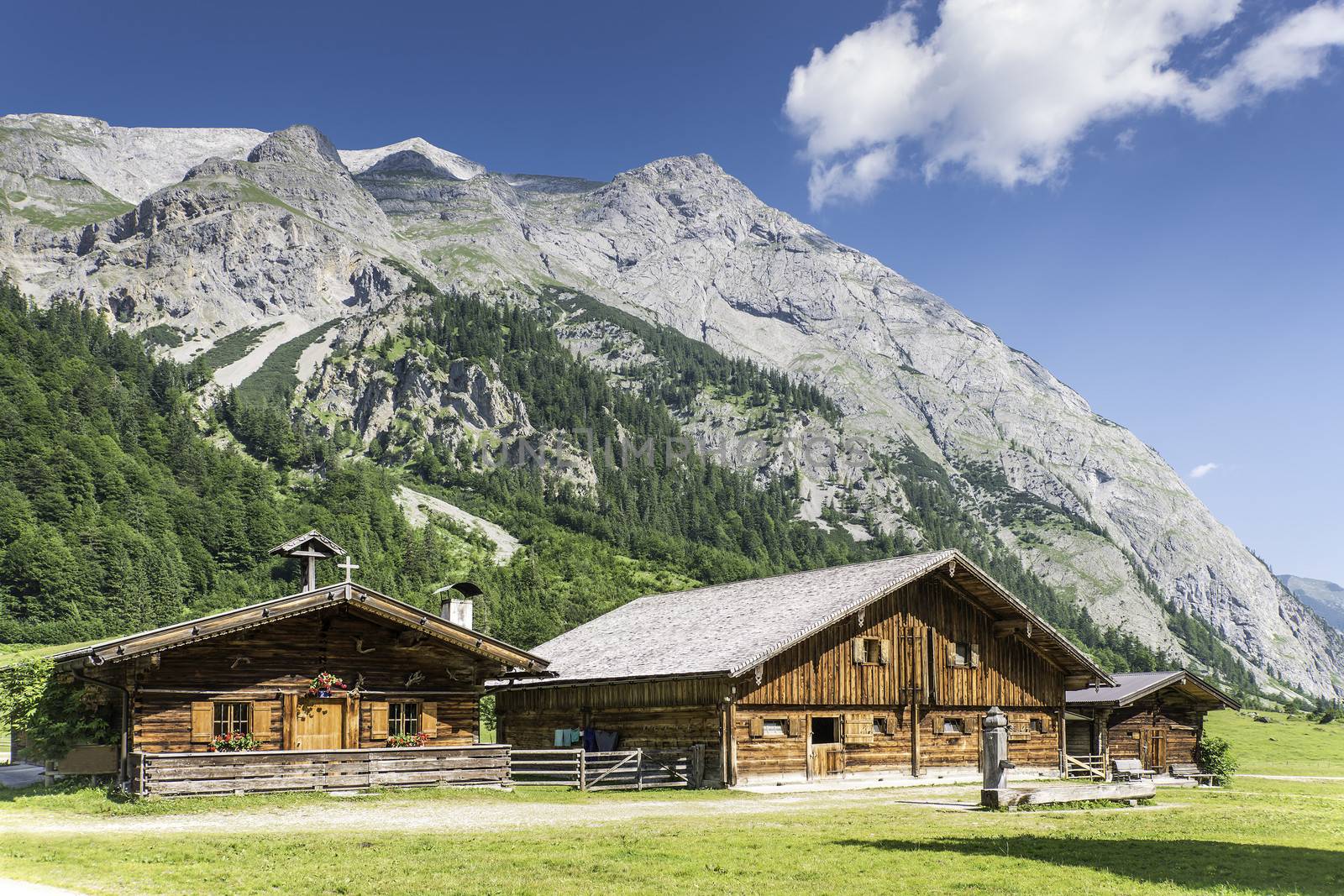 Typical mountain huts in the Austrian Alps at a place called Hinterriss, Eng on a sunny day with rocky mountains in the background