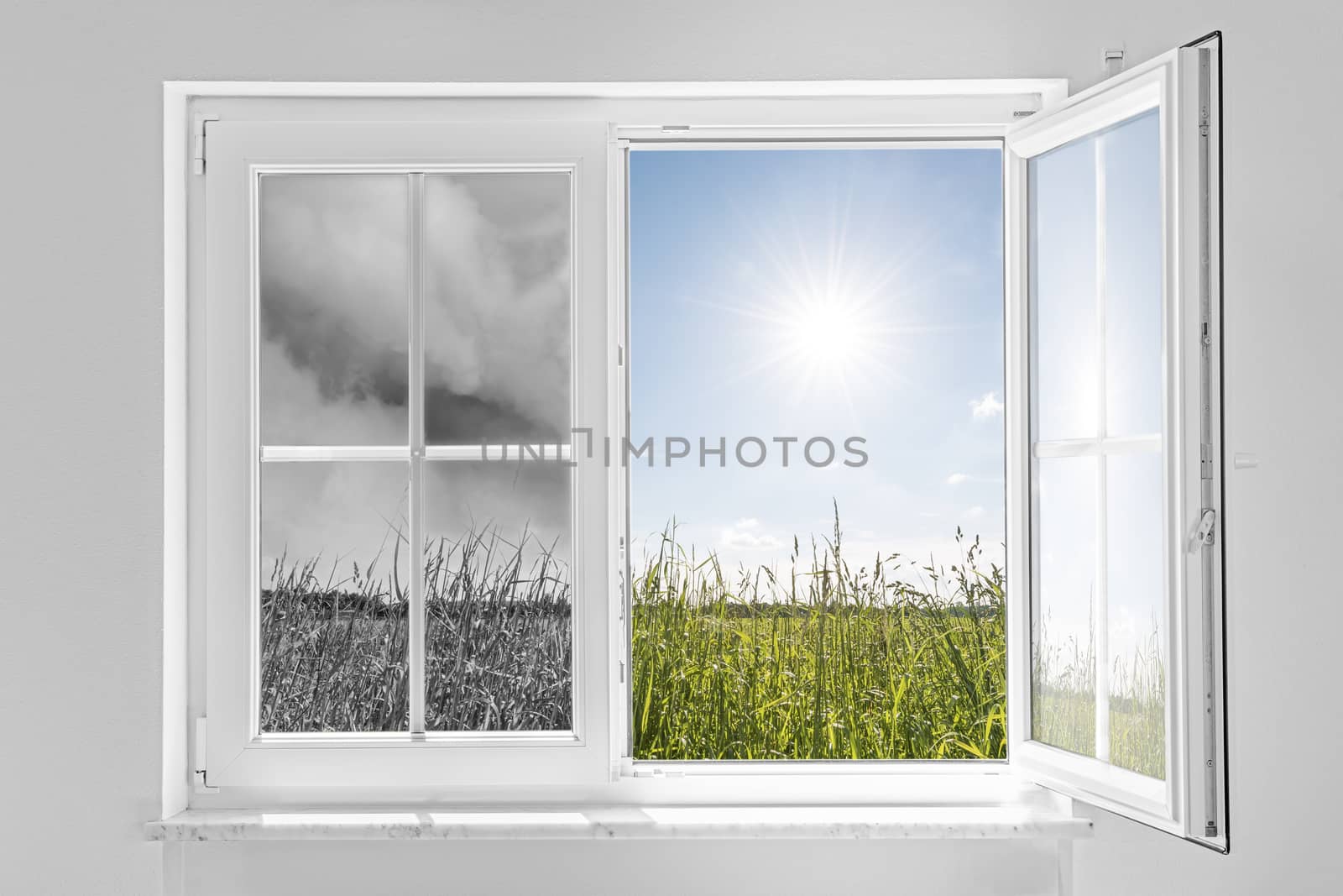 Half open window with view to the outside half on gray storm and half on clouds in blue sky with sun