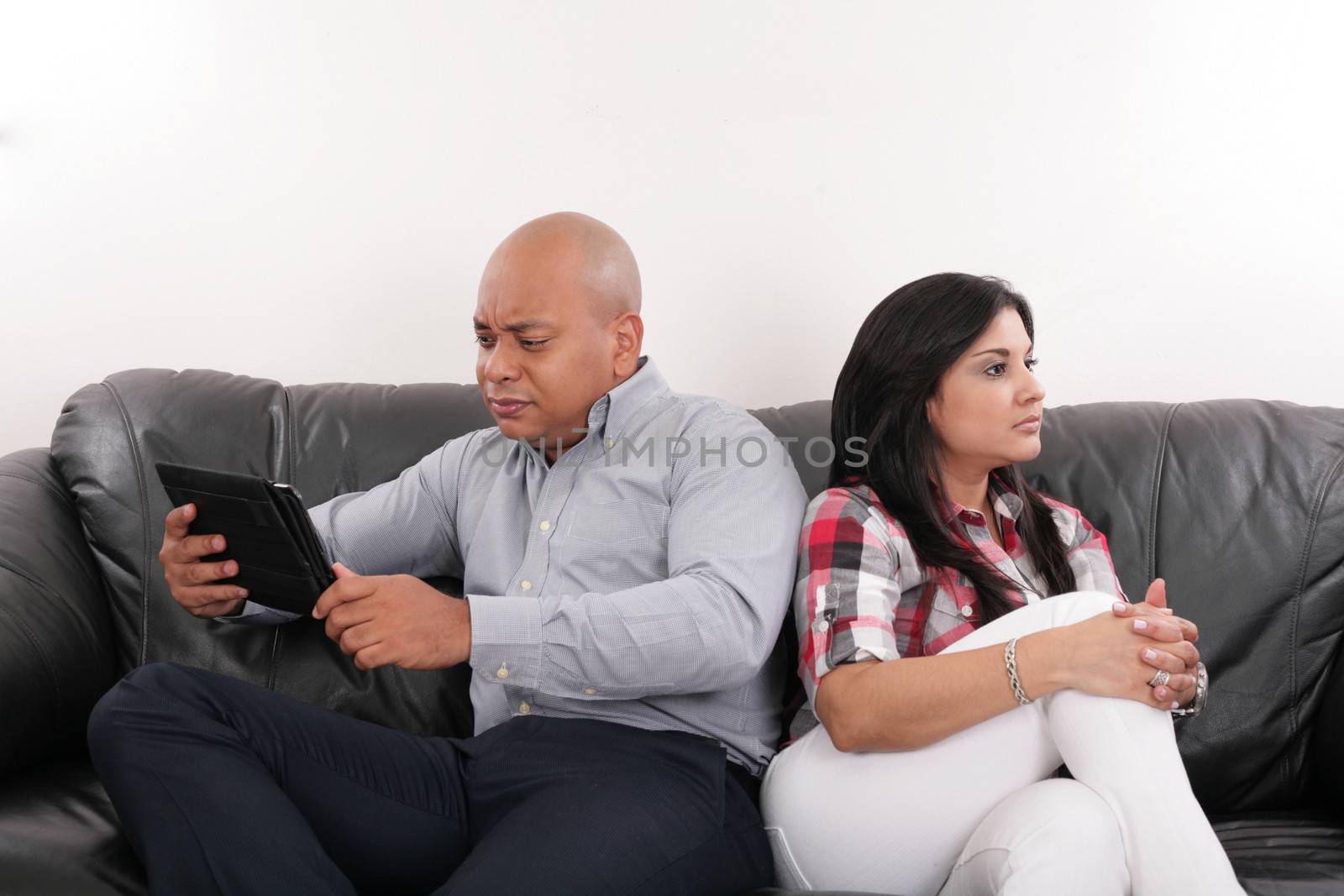 A couple having argument while sitting on the sofa