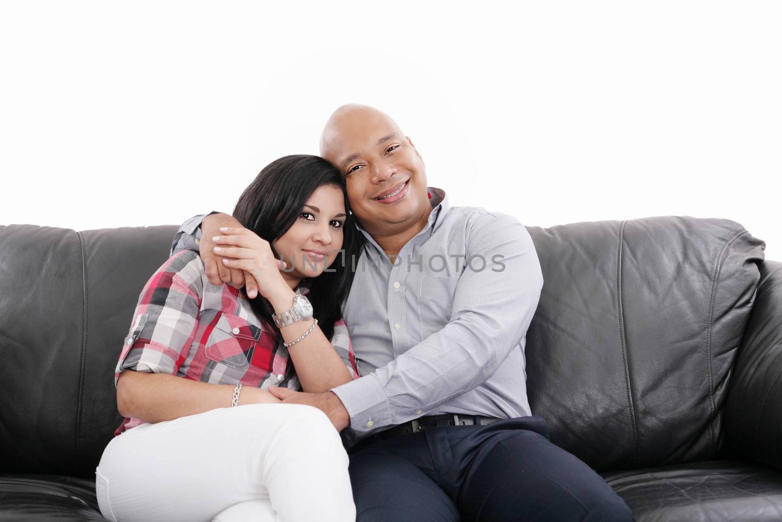 Couple sitting on a sofa while looking at the camera by dacasdo