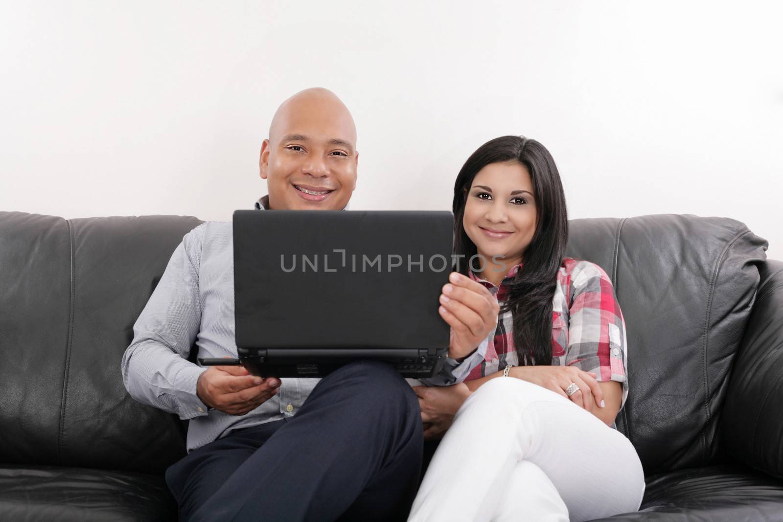 Hispanic Couple on Black Couch with Computer