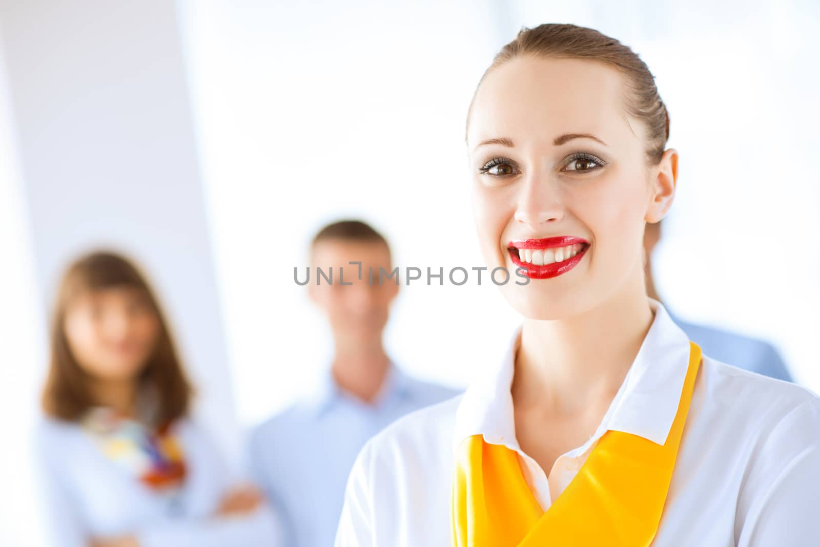 Portrait of a young successful business woman standing against colleagues