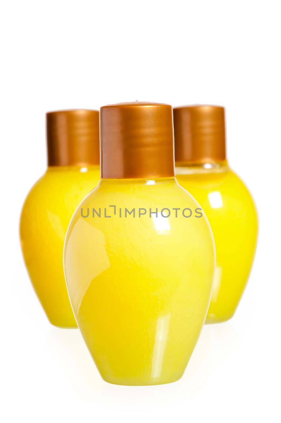 three yellow bottles of cosmetics on white background