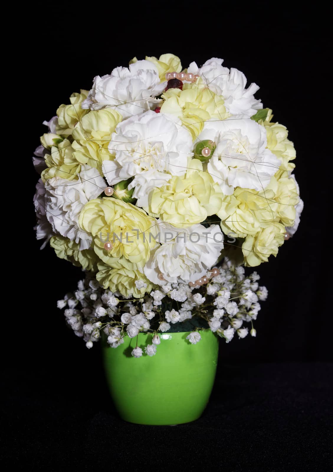 round festive bouquet of yellow carnations on a black background