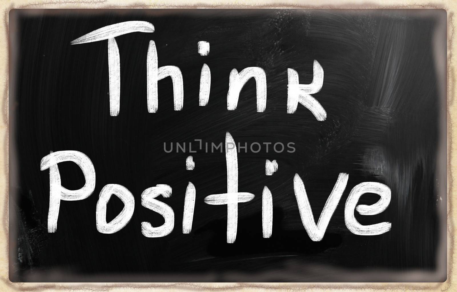 "Think positive" handwritten with white chalk on a blackboard.
