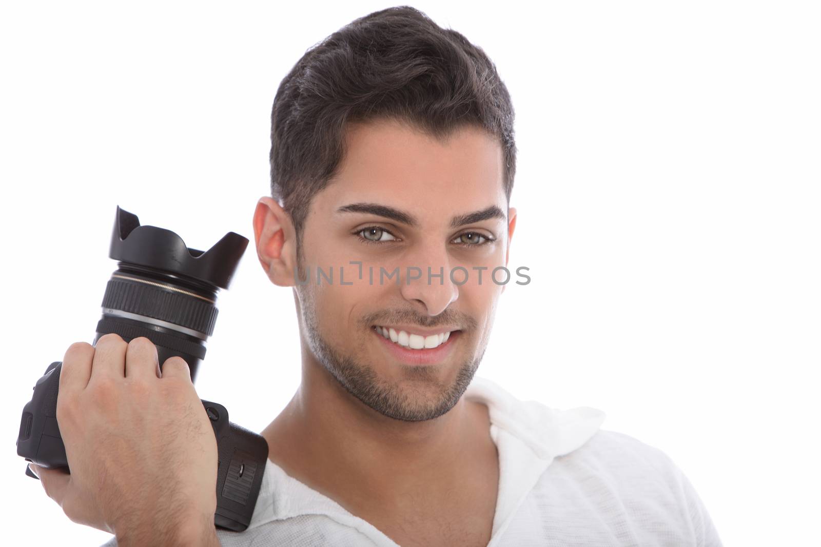 Handsome young male photographer holding a dslr camera in his hand while smiling at the camera isolated on white