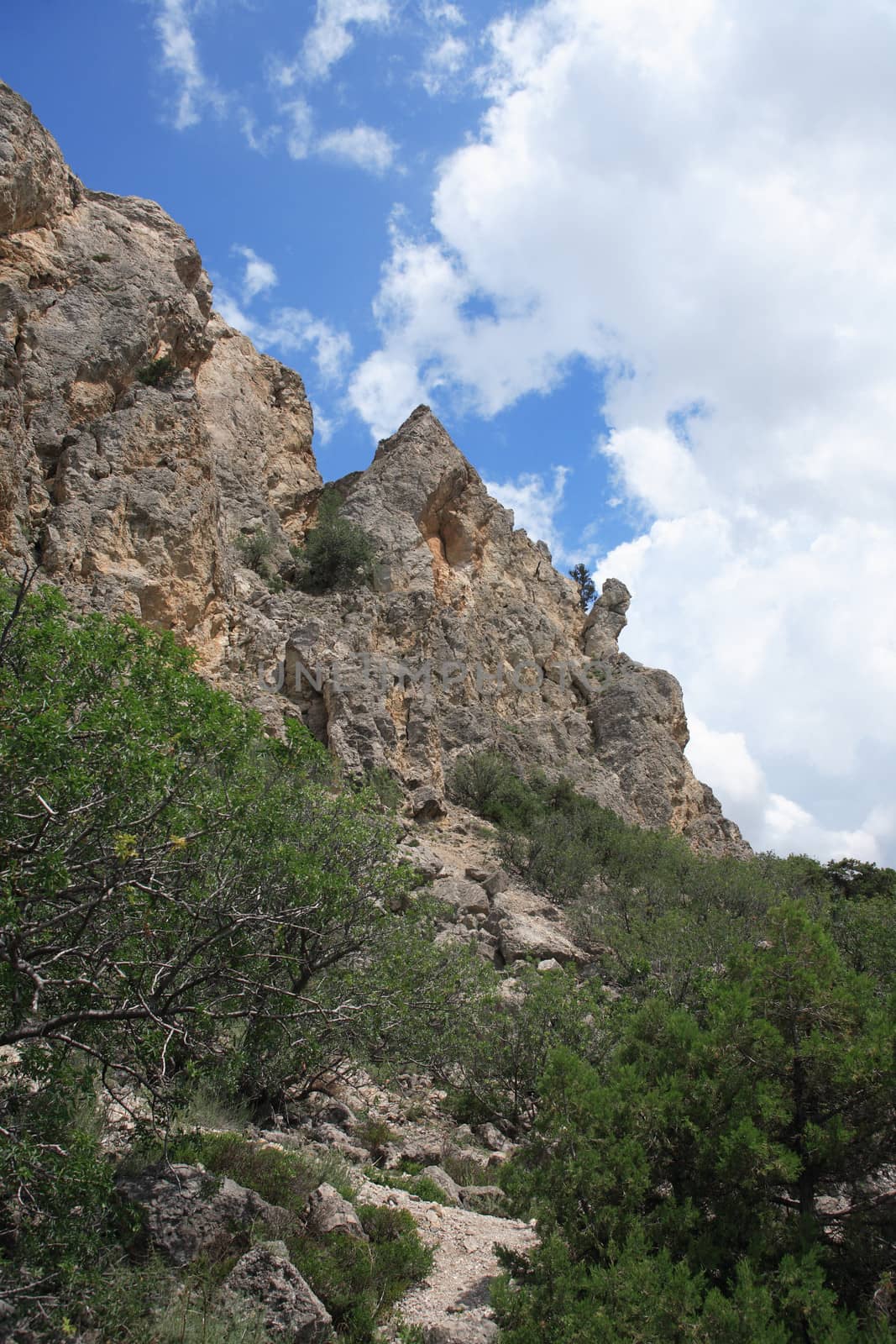 Old high mountain on background with blue sky and clouds