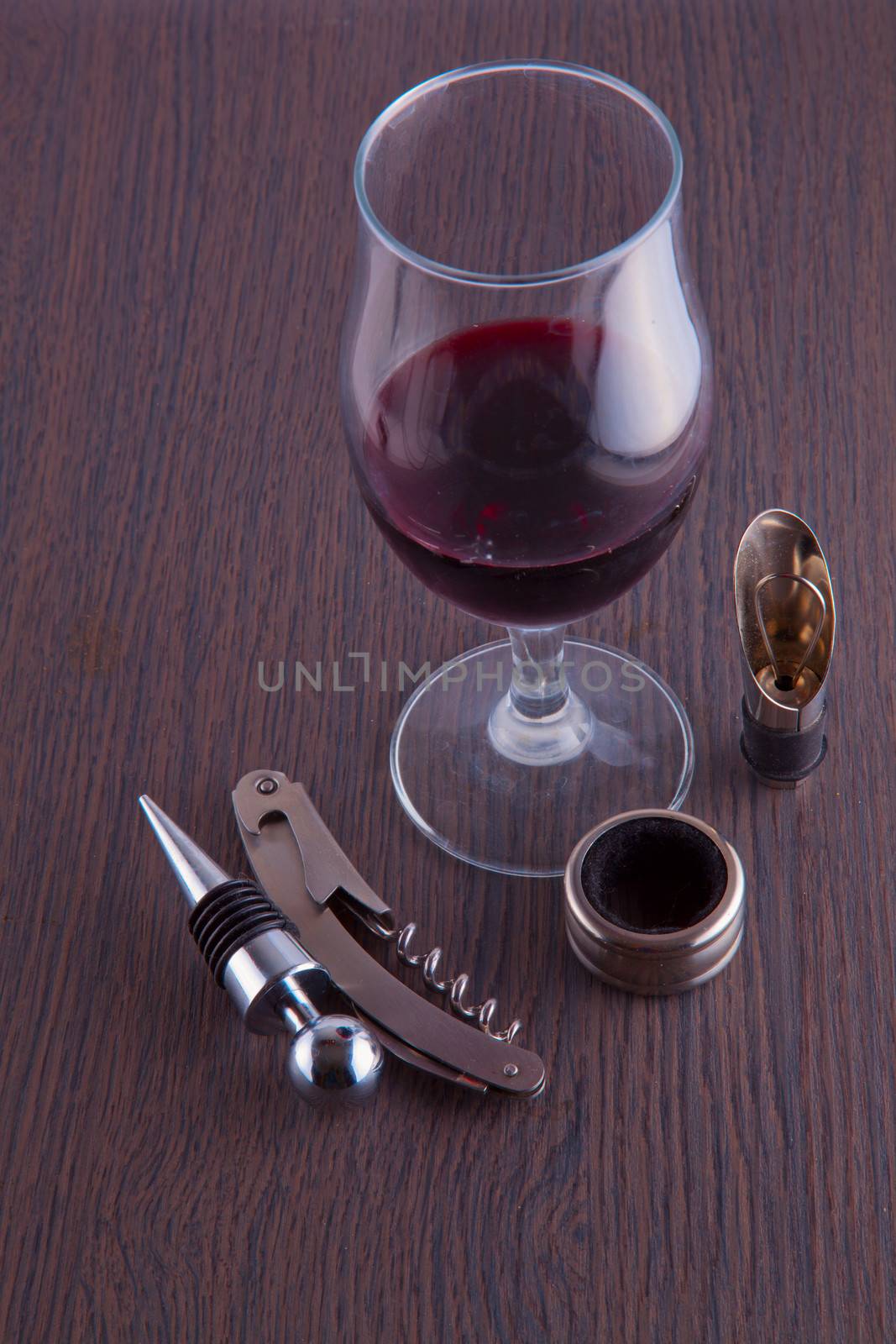 A glass of wine and tools for wine on a table