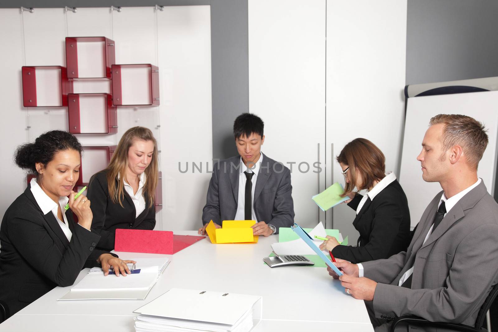 Young multiethnic business team with diverse men and women having a meeting around a conference table