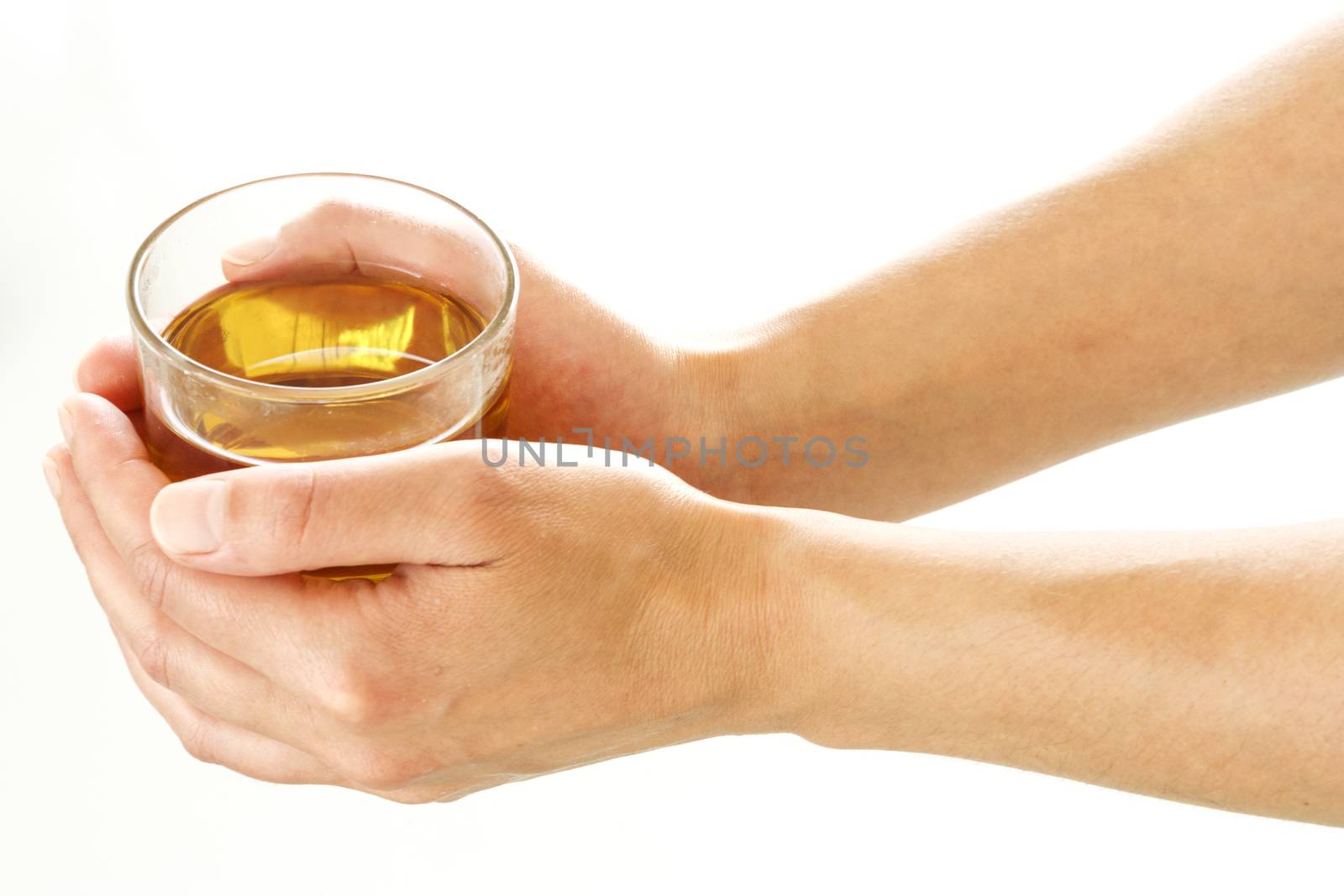 Female hands holding a glass of tea over a white background