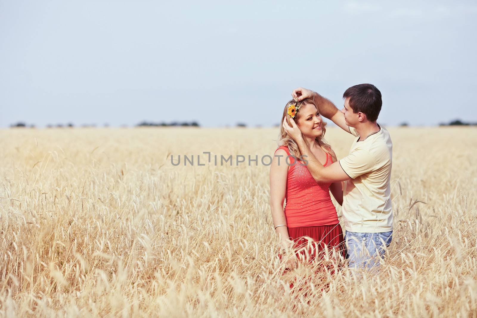 Guy catches a flower girl in a wheat field