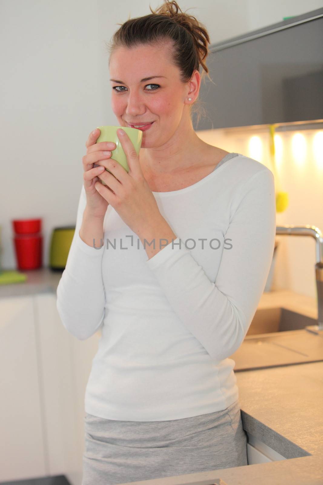 Housewife drinking coffee in her kitchen by Farina6000