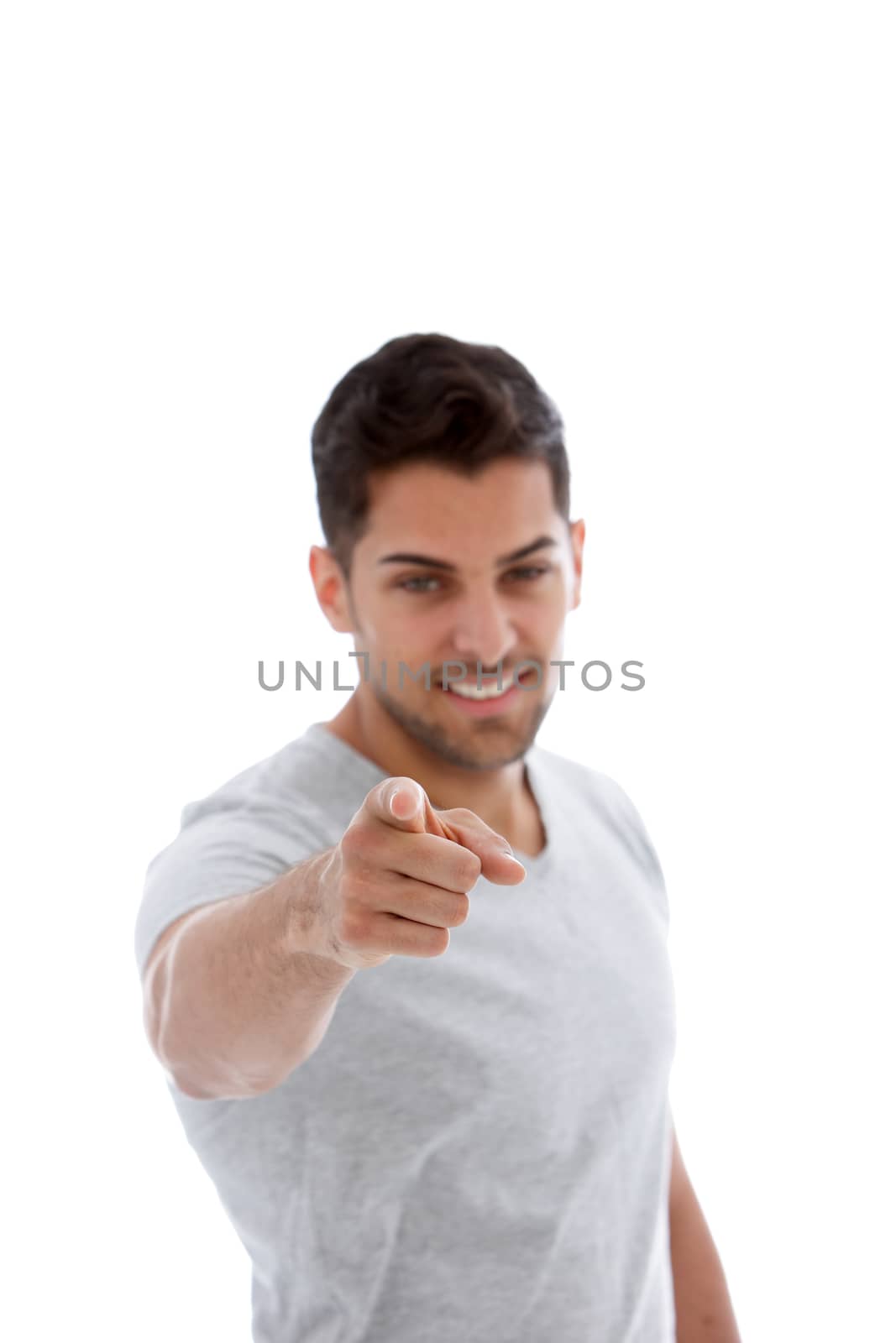 Handsome unshaven young man pointing at the camera with his finger making a choice or identifying someone isolated on white
