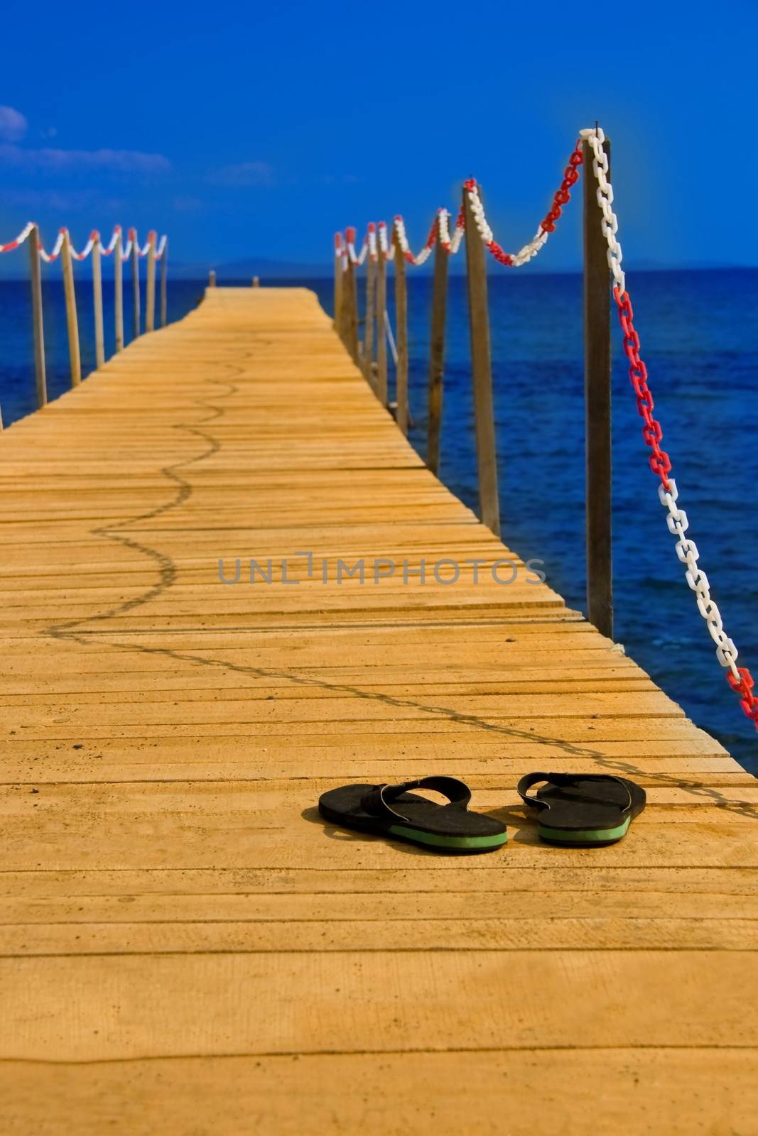 slippers on wooden peer consept of going vacation