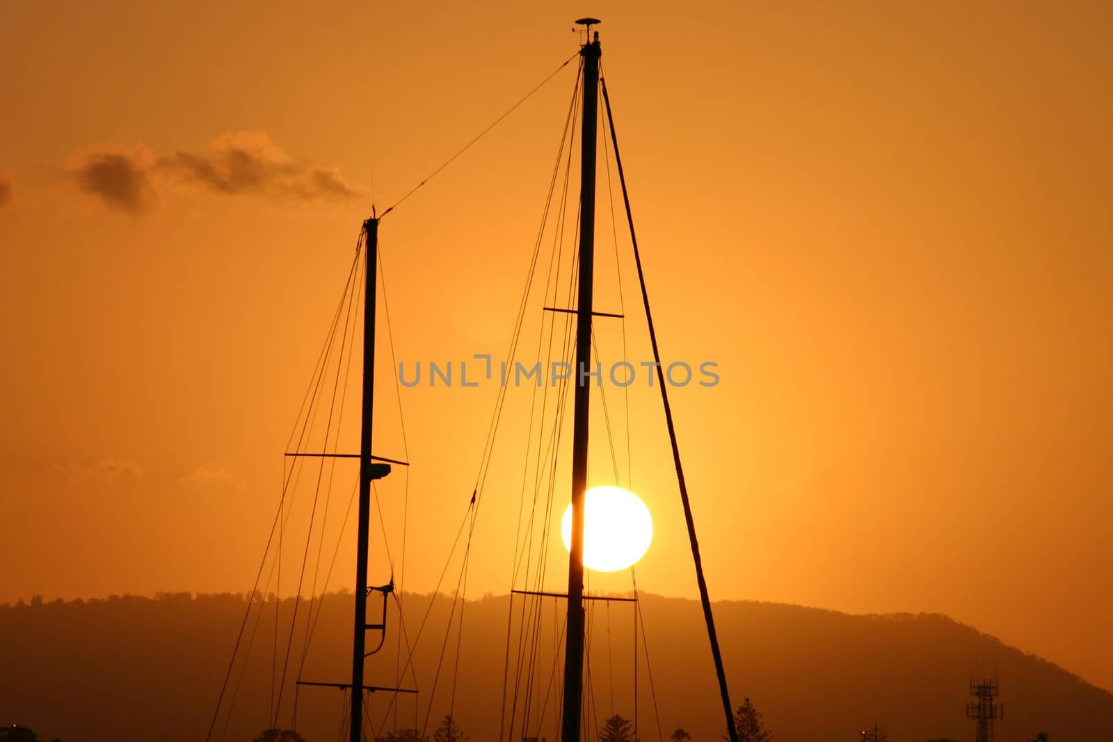 Two masts framed against the setting sun.