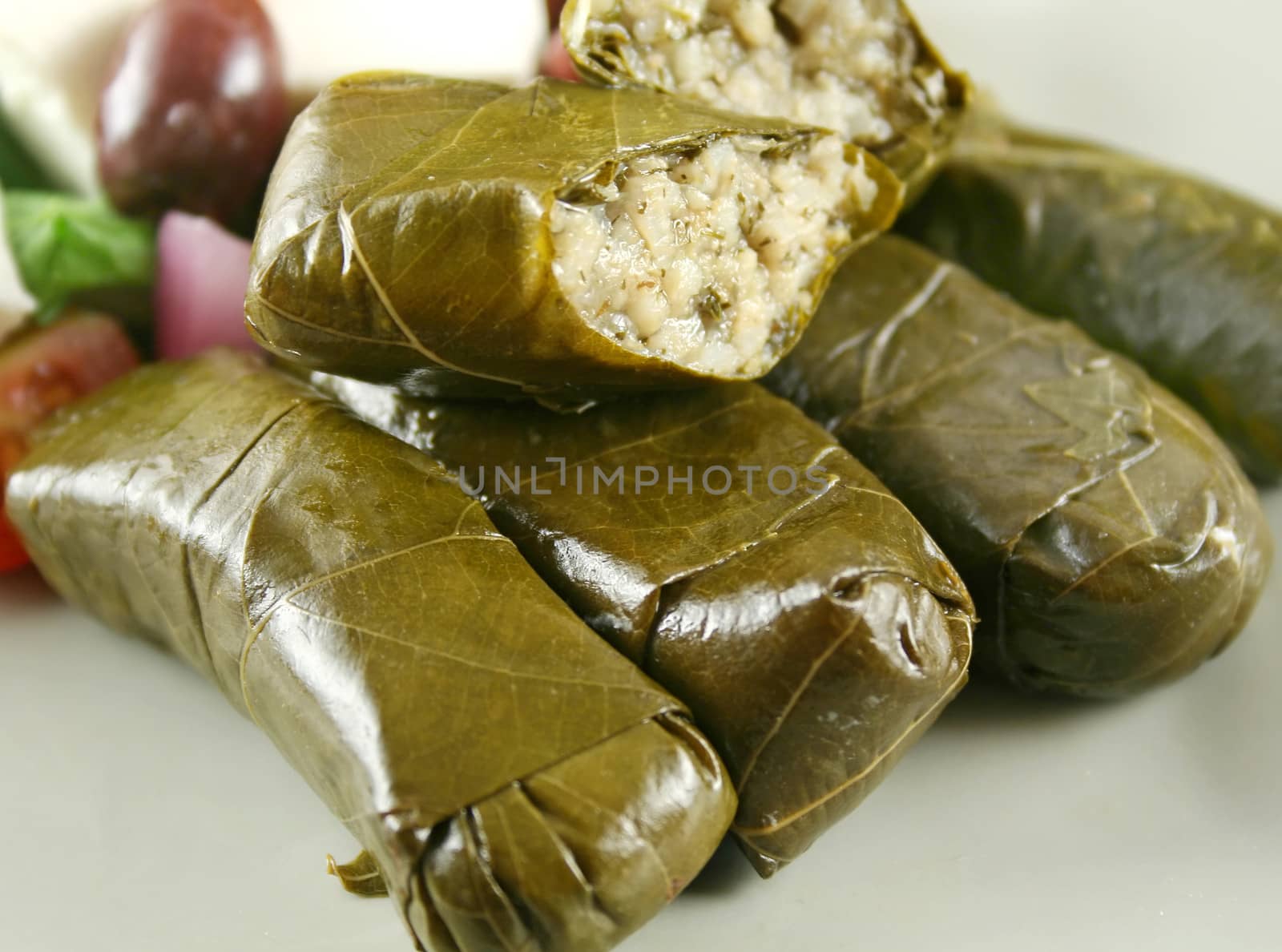 Greek dolmas wrapped with vine leaves and rice with salad.