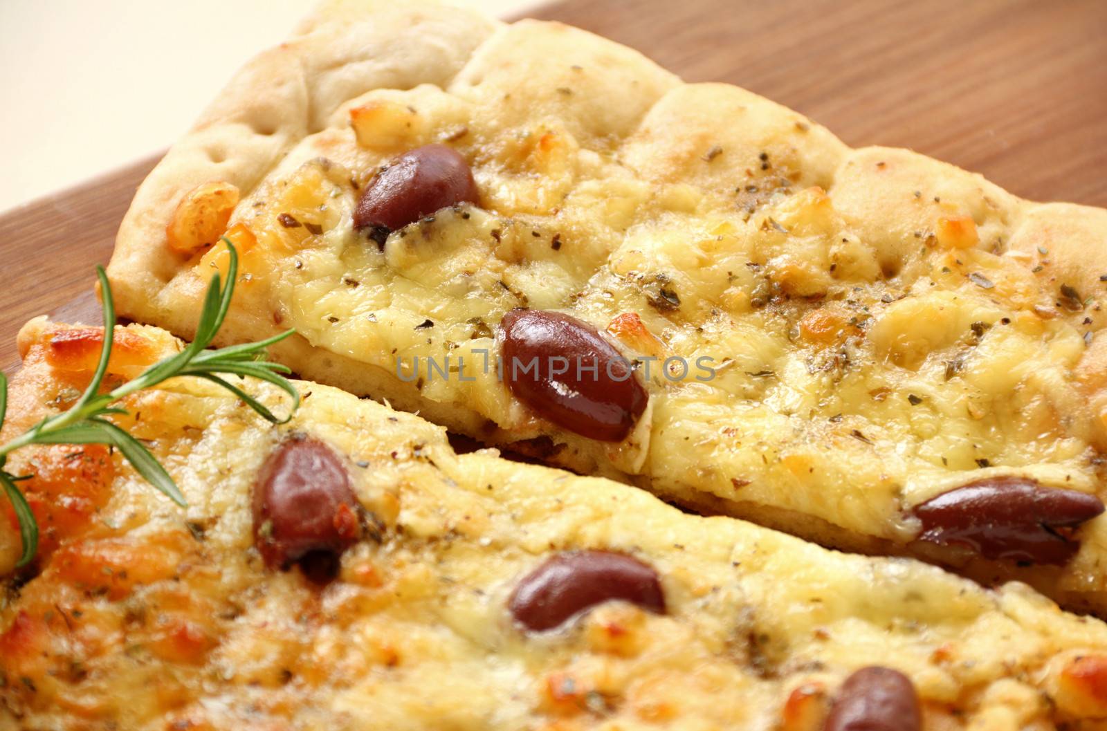 Rectangular gourmet pizza with cheese and olives ready to serve.
