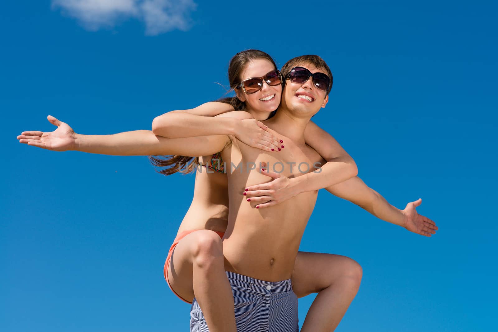 Young couple hugging on a background of blue sky, hold together honeymoon