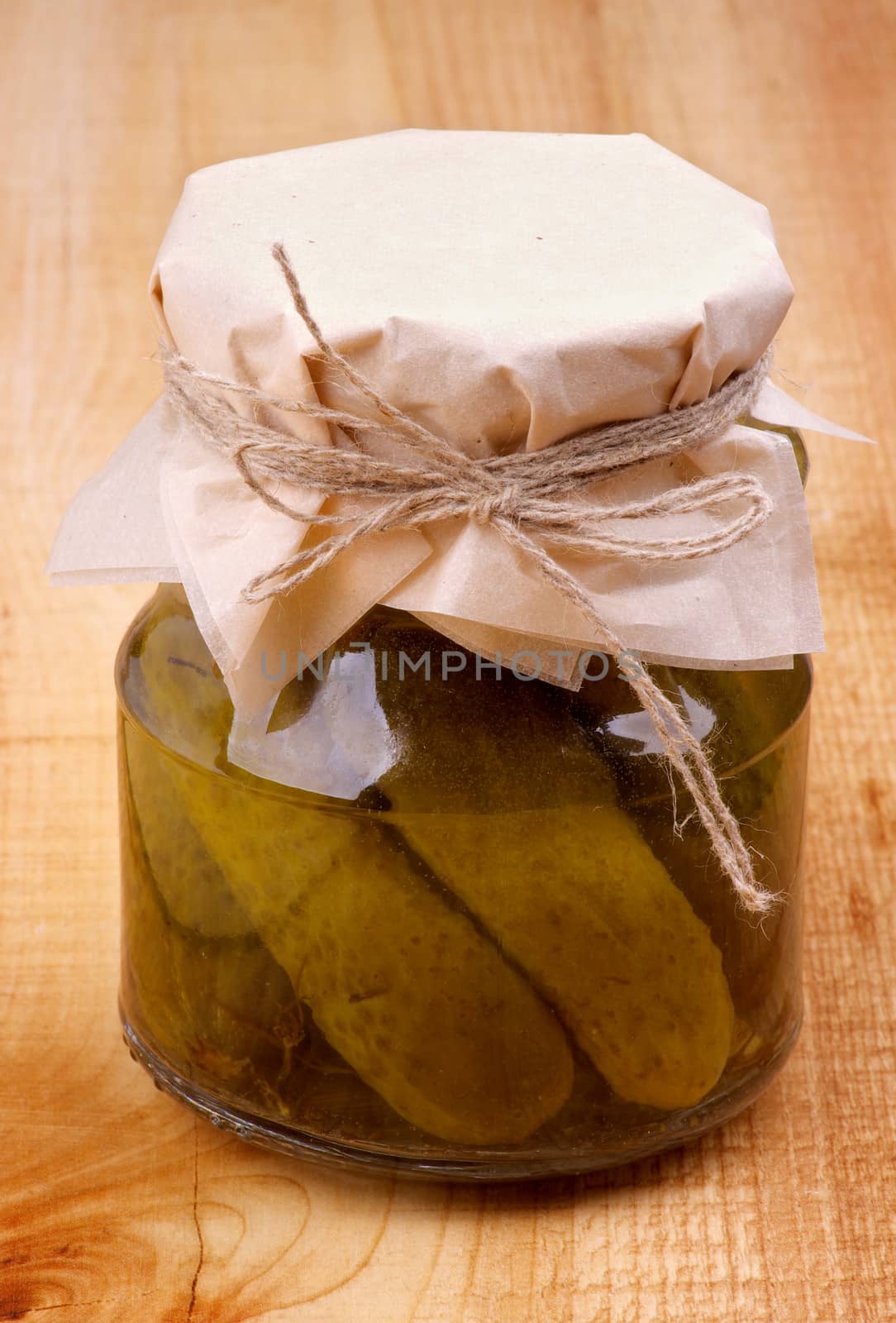 Glass Jar with Homemade Pickled Cucumbers on Wooden background