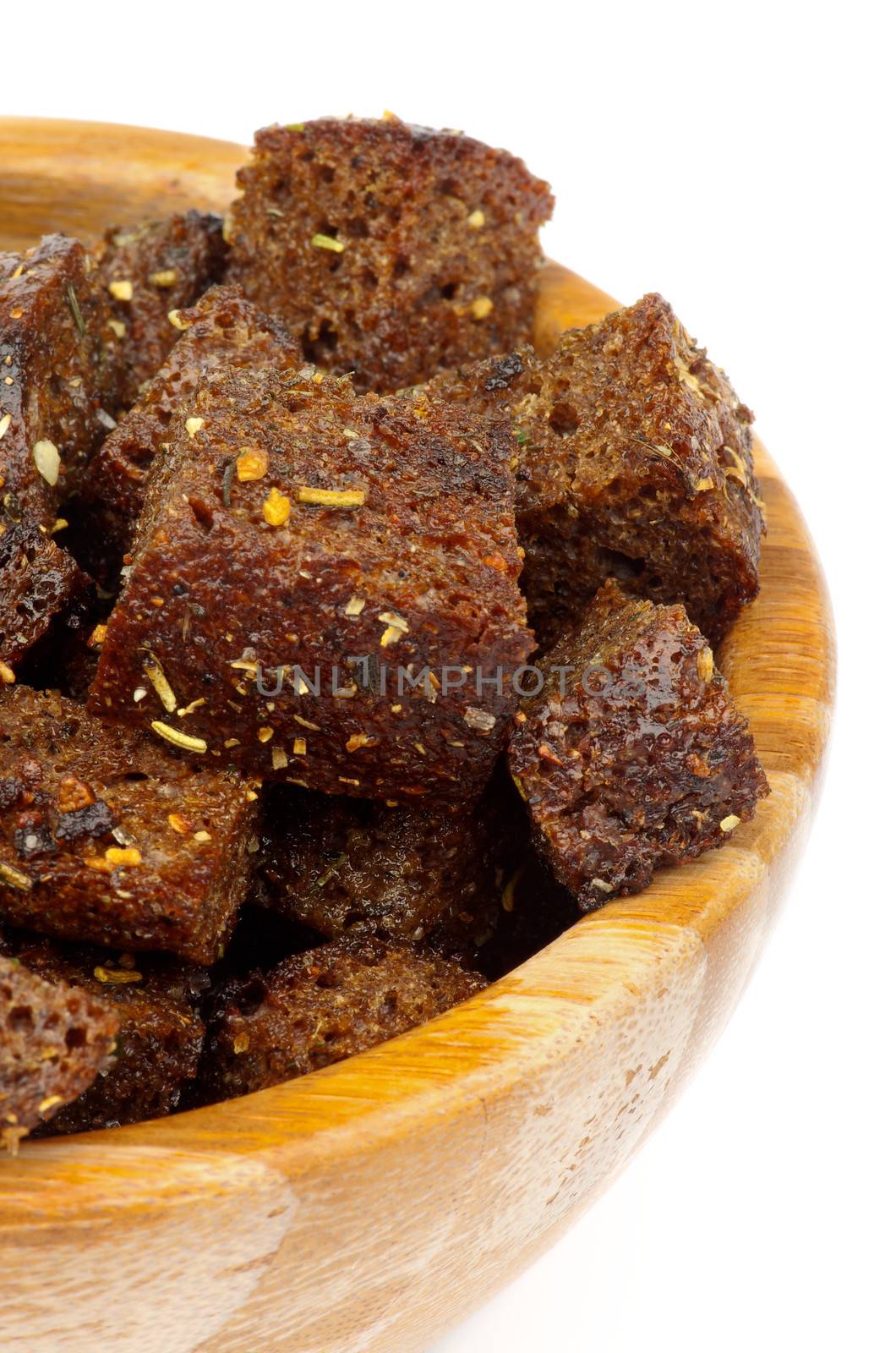 Tasty Whole Grain Bread Croutons with Garlic and Spices closeup in Wooden Bowl