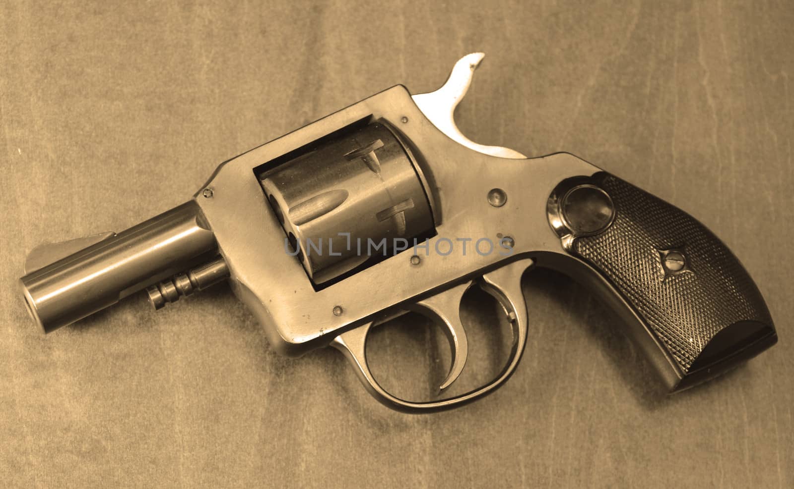 a small handgun on a wooden background in sepia with nobody