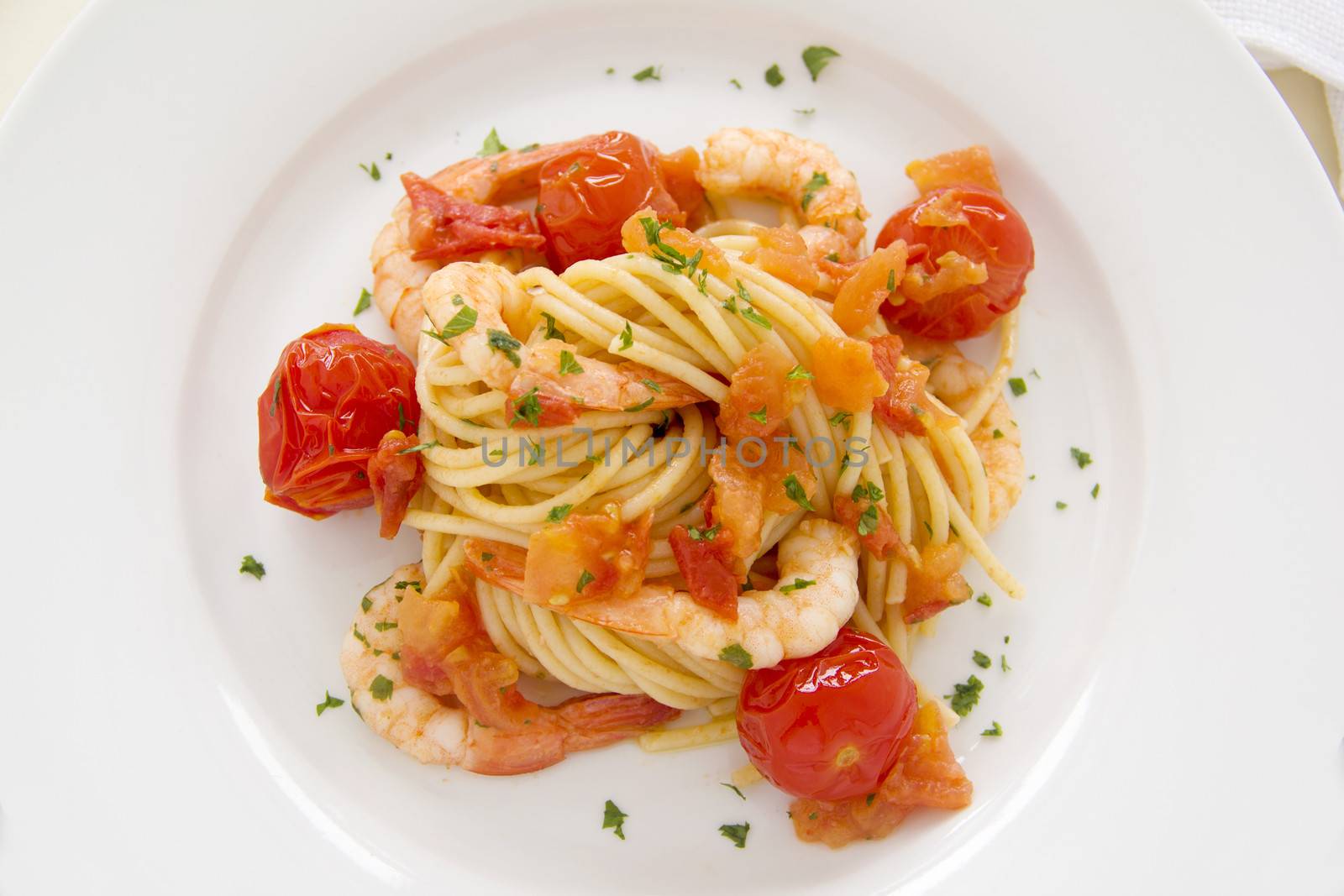 Delicious fresh shrimps and spaghetti with cherry tomatoes and parsley.