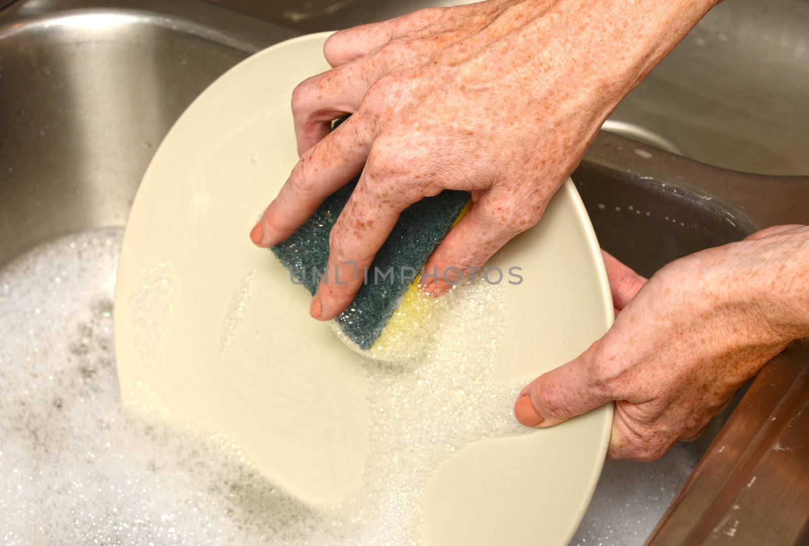 cleaning plate in soapy water while doing dishes