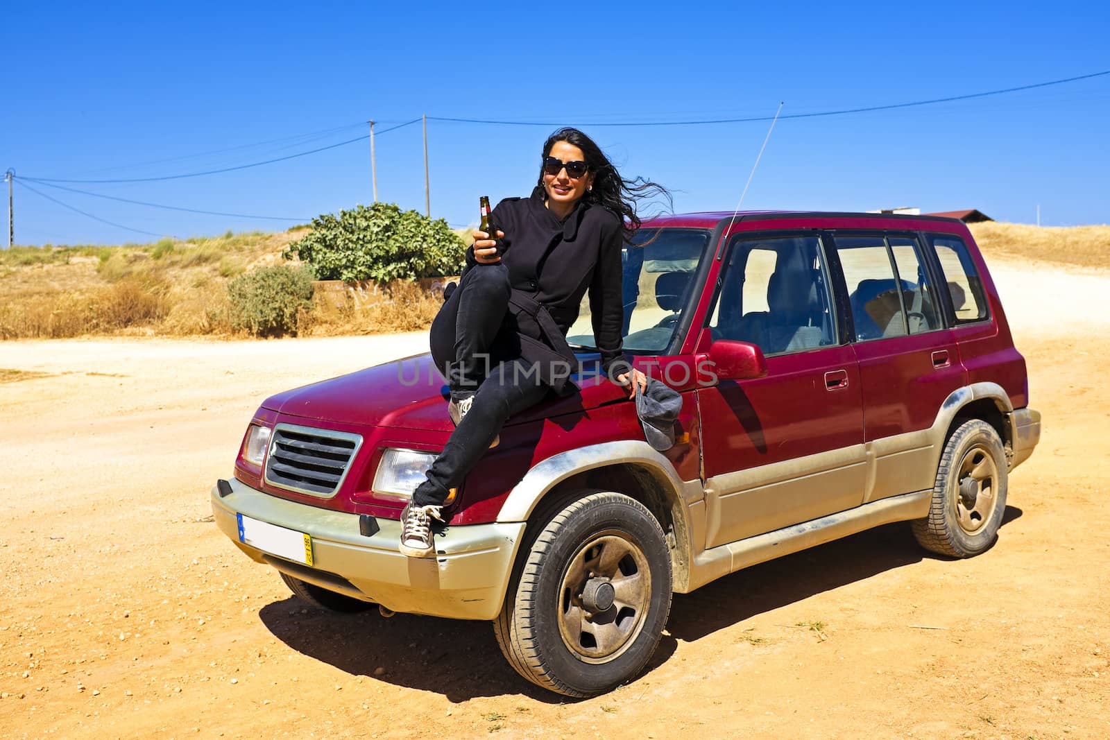 Woman drinking beer in the desert