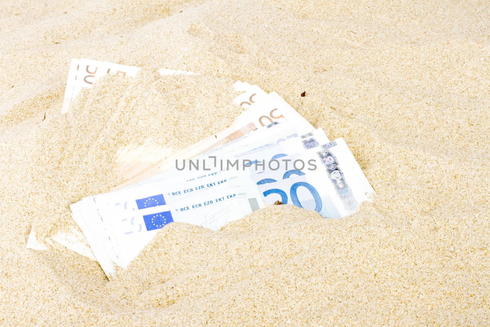 Euro banknotes in the sand