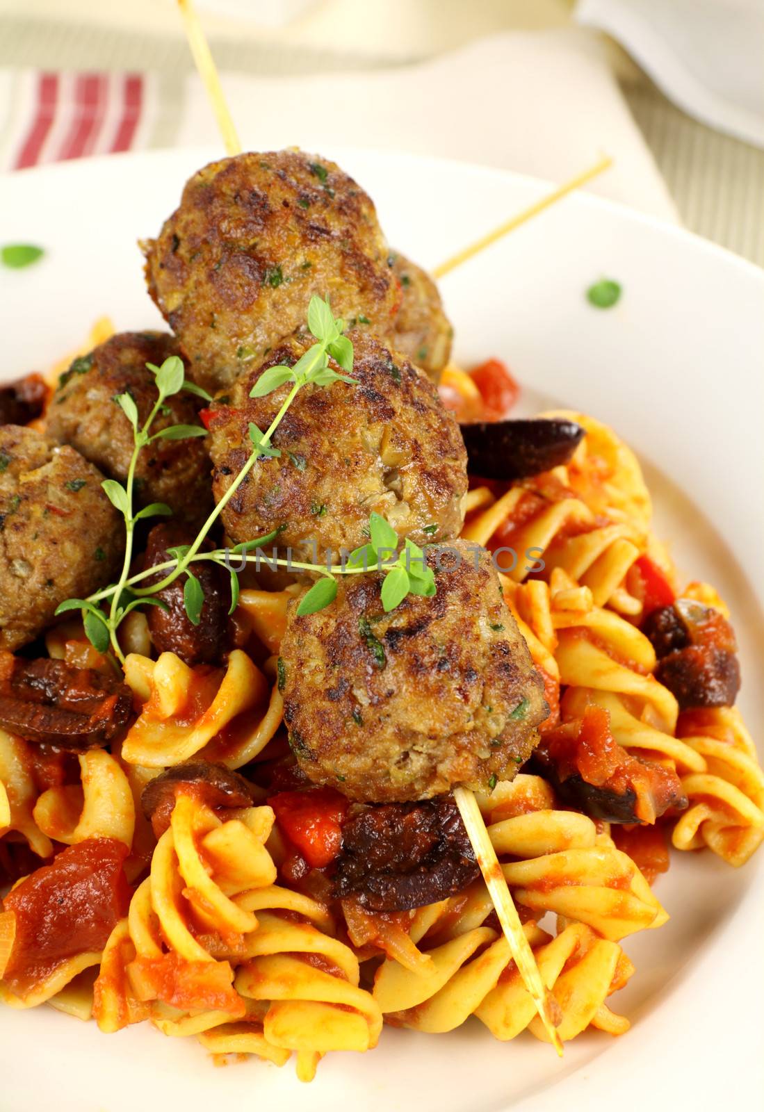 Delicious beef meatballs on tomato and olive pasta.