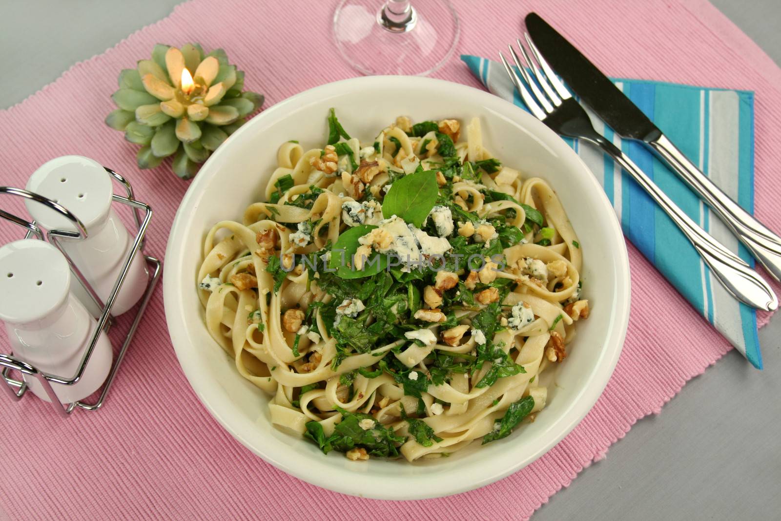 Fettucini with spinach blue cheese and walnuts with a mint garnish.