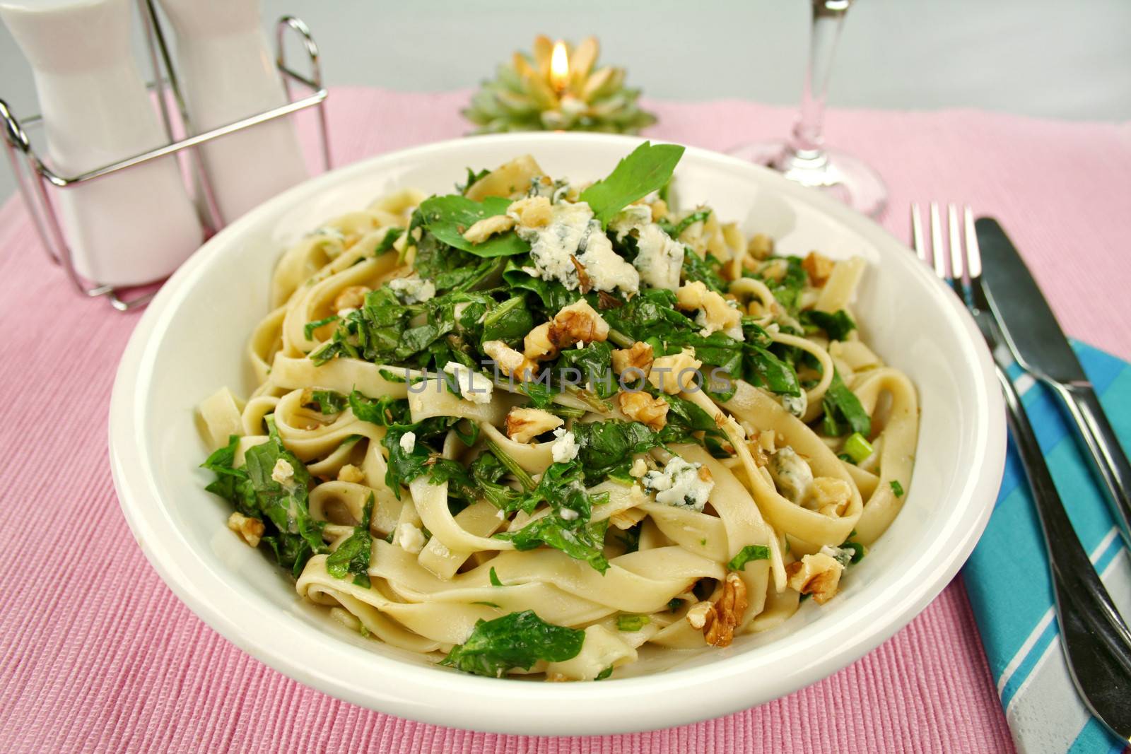 Fettucini with spinach blue cheese and walnuts with a mint garnish.