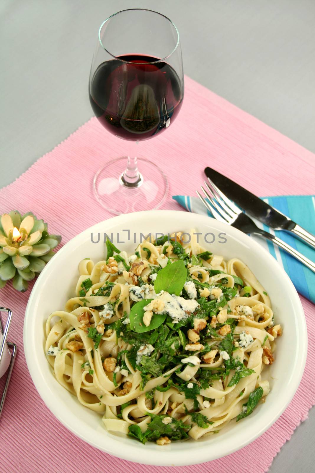 Fettucini with spinach blue cheese and walnuts with a mint garnish.