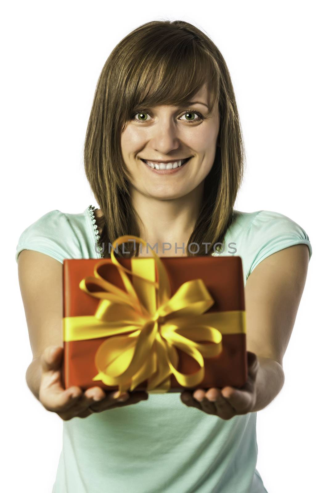 Happy young brunette girl with green eyes and green shirt holding a red gift box with golden ribbon