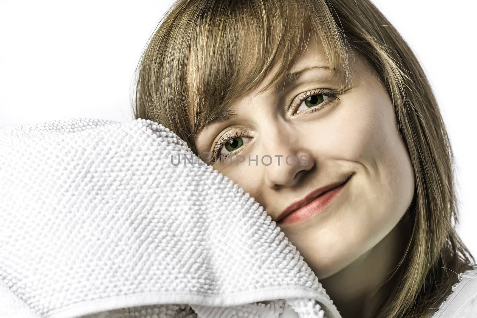 Portrait of a young girl with green eyes set, snuggled in a white towel, isolated on white background