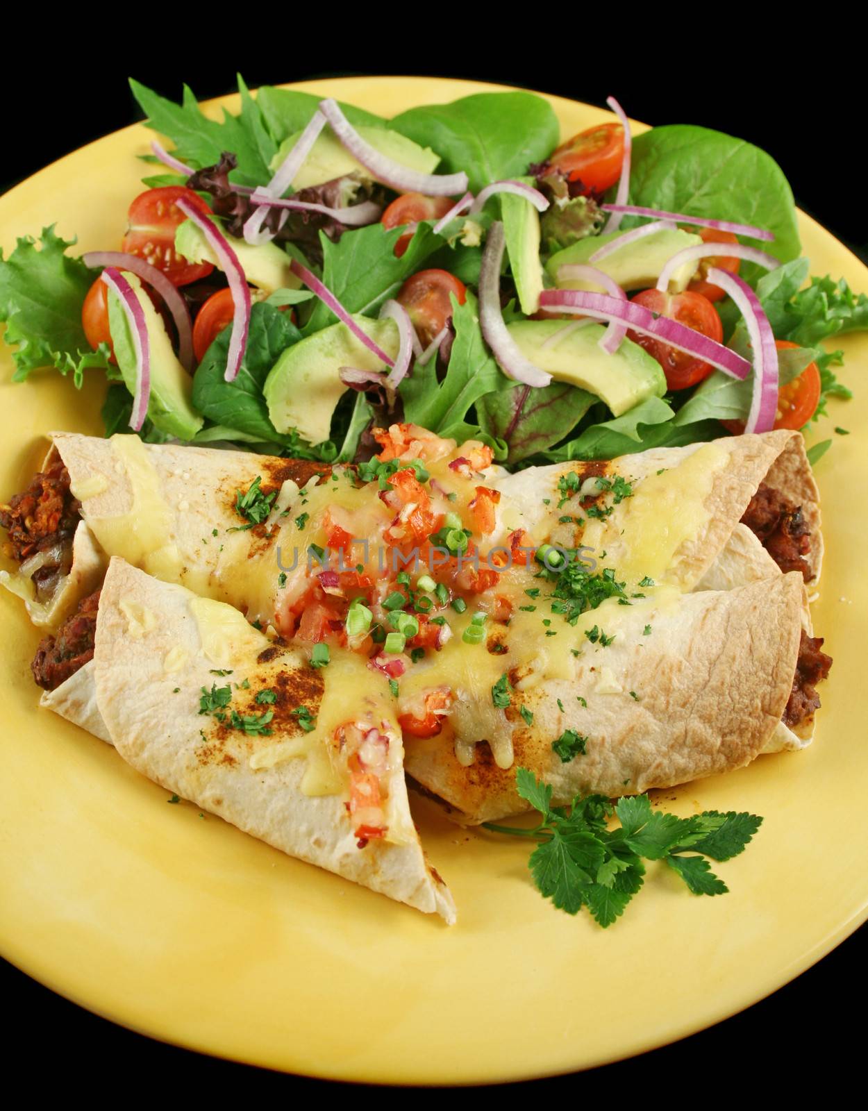 Beef and red kidney bean enchiladas with cheese and salad.