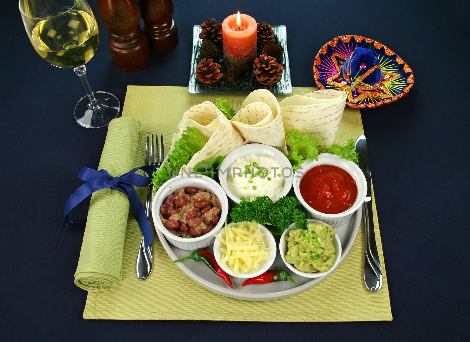 Mexican vegetarian platter with tortillas, guacamole, refried beans, cheese, sour cream and tomato salsa,