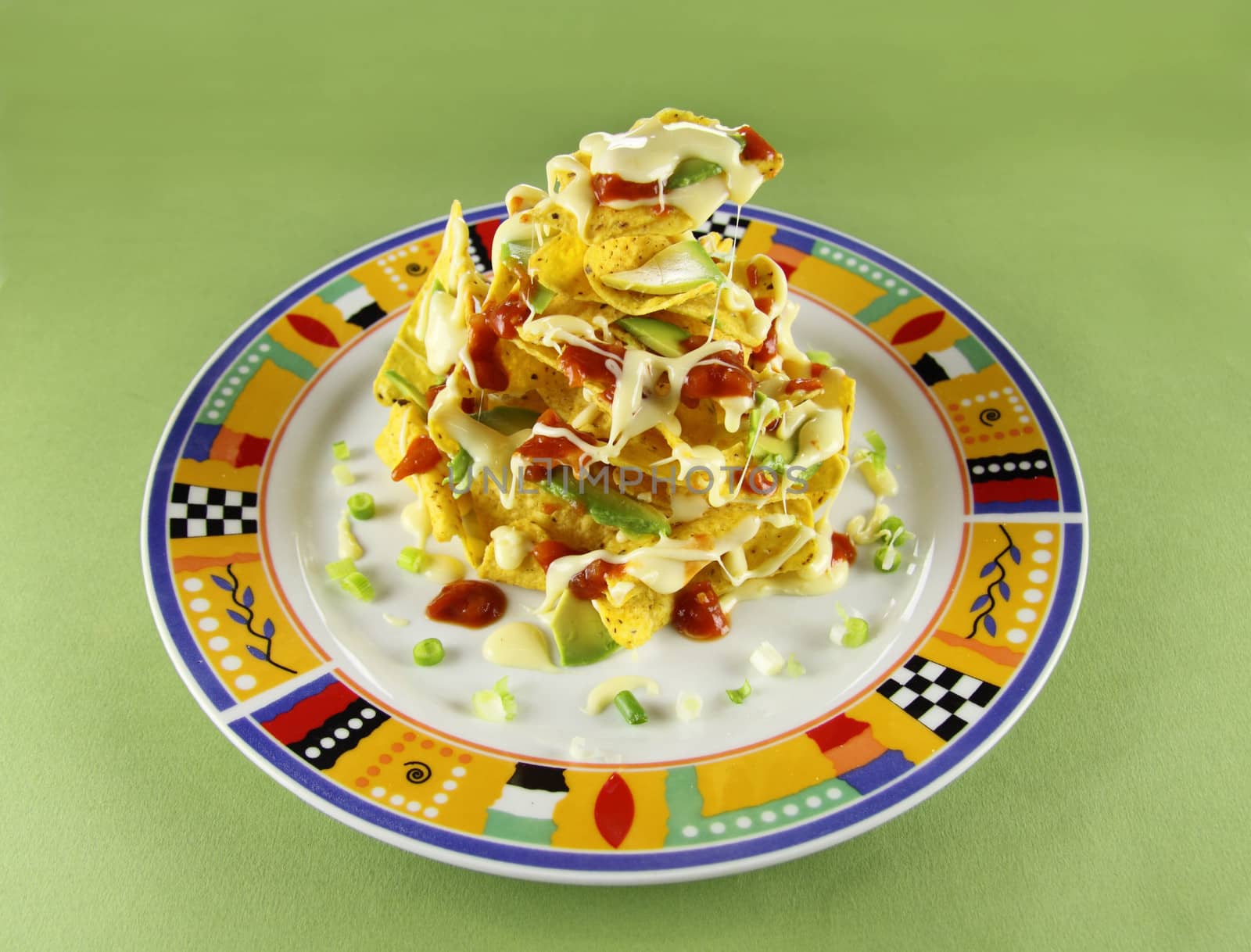Delicious stack of nachos with guacamole and melted cheese.
