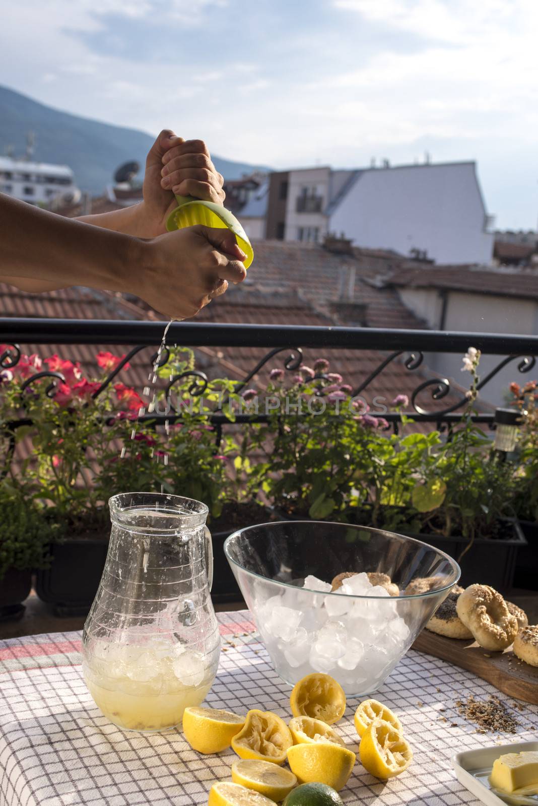 Preparation of fresh lemon juice on a terrace, city background