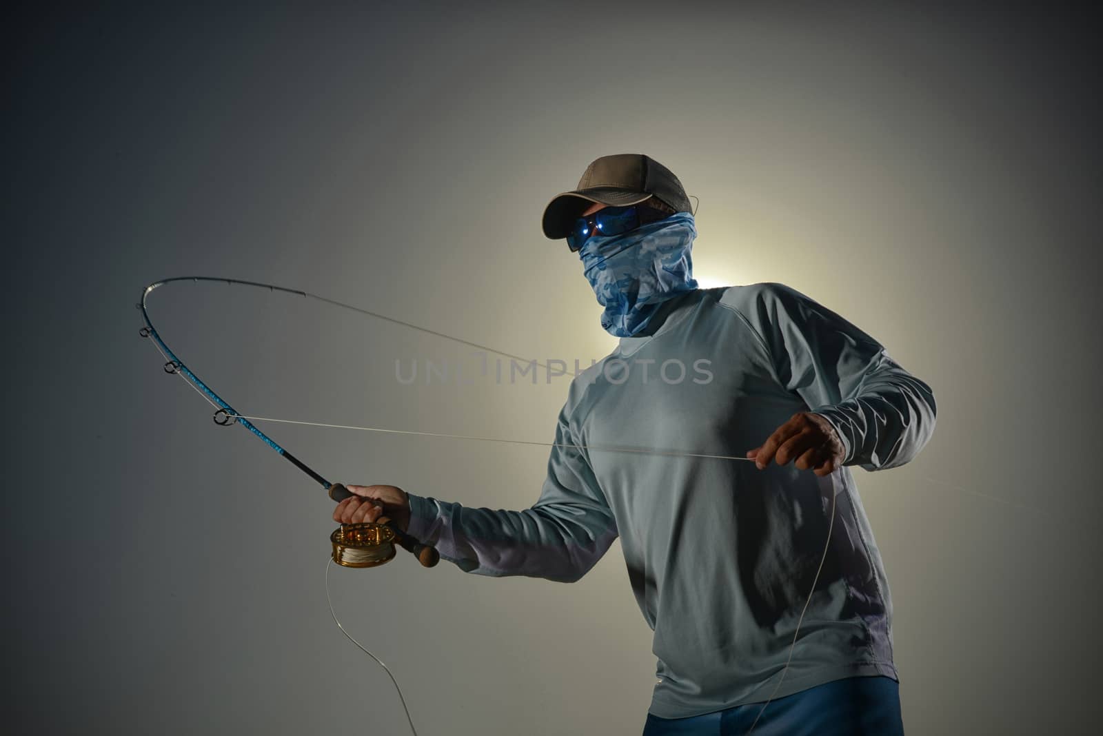 guy casting while fishing against a plain background