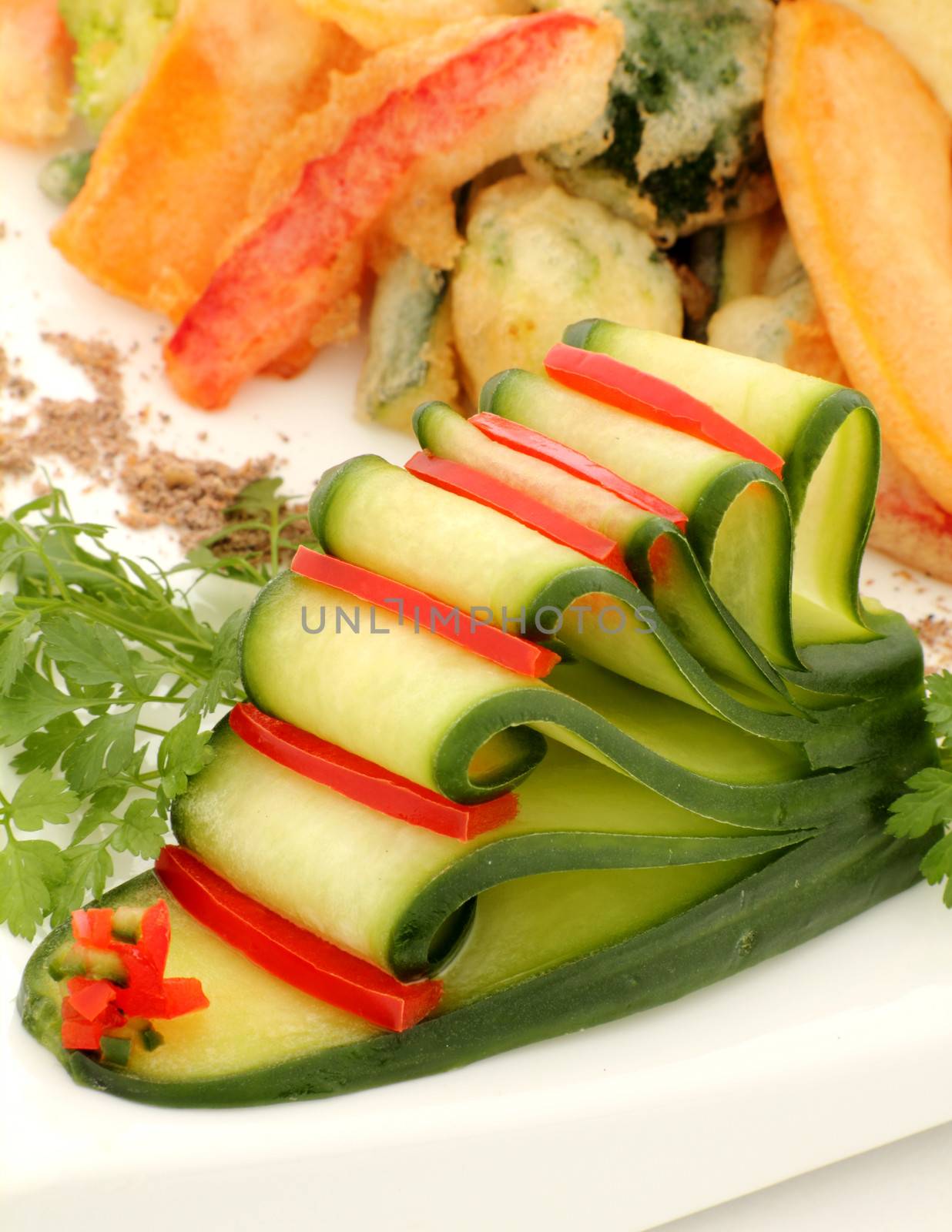 Garnish of sliced cucumber with capsicum strips with tempura and fresh parsley.
