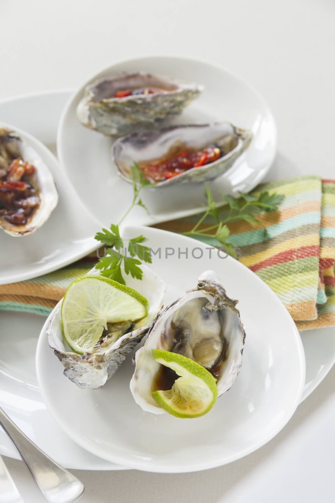 Platter of oysters including oysters kilpatrick, with sweet chilli and with lime and soy sauce.