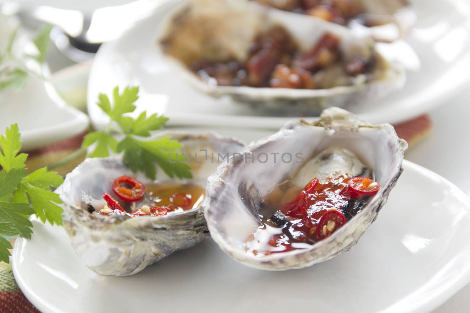 Platter of oysters with sweet chilli oysters and oysters kilpatrick with parsley.